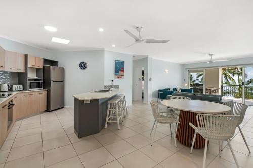 a kitchen and living room with a table and chairs at Relax at Trinity in Trinity Beach