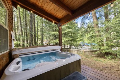 a jacuzzi tub on a deck in the woods at Chipmunk Lodge by NW Comfy Cabins in Leavenworth