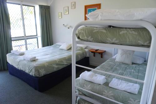 a bedroom with two bunk beds and a window at Ocean View Motel Bowen in Bowen