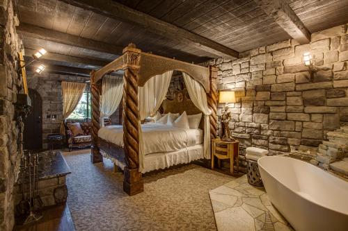 a bedroom with a bed and a tub in a room at Storybook Riverside Inn in Leavenworth