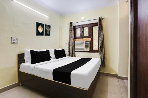 a bedroom with a large bed with a window at Hotel O Dwarka Metro in New Delhi
