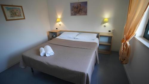 a bedroom with a bed with two white towels on it at Charme by the Sea, Sant'Andrea in SantʼAndrea Apostolo dello Ionio