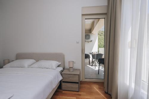 a bedroom with a bed and a balcony with a table at Status-M Аpartments 173 in Bečići