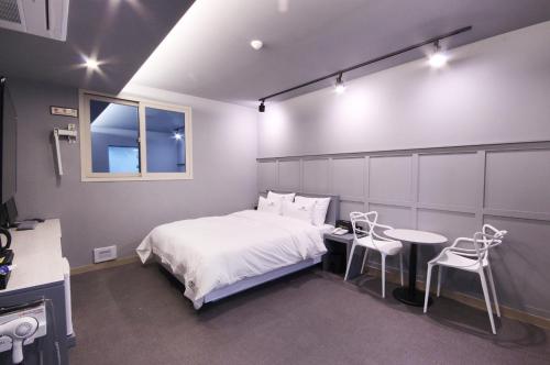 a bedroom with a bed and a table and chairs at Novahotel in Samgong