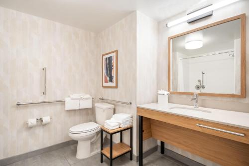 a bathroom with a toilet and a sink and a mirror at Hampton Inn Rutland/Killington in Rutland