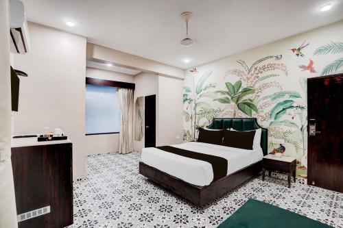 a bedroom with a bed and a wall with a mural at Townhouse Chandpole Metro Station Formerly Hotel Raghuraj Palace in Jaipur
