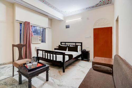 a bedroom with a bed and a couch and a table at Townhouse Chandpole Metro Station Formerly Hotel Raghuraj Palace in Jaipur
