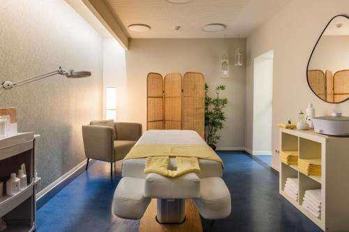 a dermatology room with a table and a mirror at IFA Schöneck Hotel & Ferienpark in Schöneck