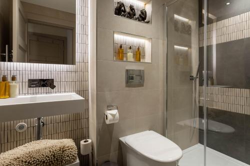 a bathroom with a shower and a toilet and a sink at Arran Shores Luxury Shorefront Apartment 3 in Lamlash