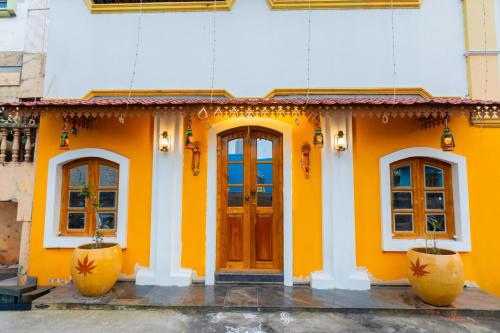 a yellow building with three windows and a door at Sri Balaji Villas Pondicherry with Car Parking in Pondicherry