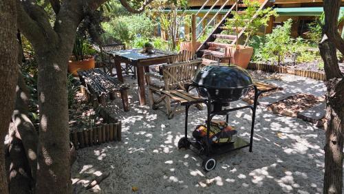 a backyard with a grill and a table and chairs at Noordhoek Beach Cabin in Noordhoek