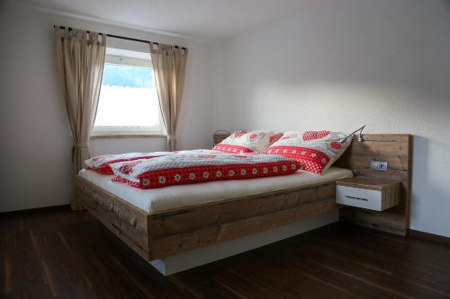 Un dormitorio con una cama con almohadas rojas y una ventana en Ferienwohnung Köchl, en Münster