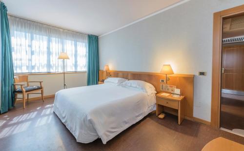 a hotel room with a large bed and a window at Caesar's Hotel in Cagliari