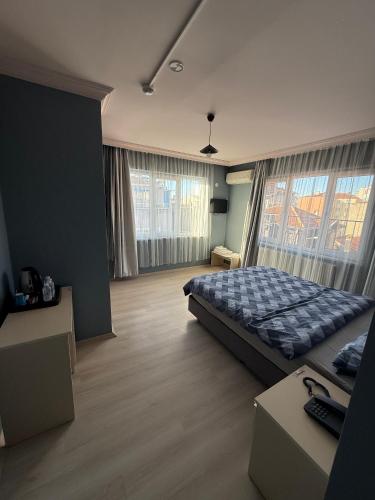 a bedroom with a bed and a large window at Flora Otel 16 rooms in Edirne