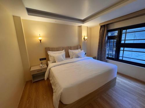 a bedroom with a large white bed and a window at Juniper Mountain Resort in Lachen