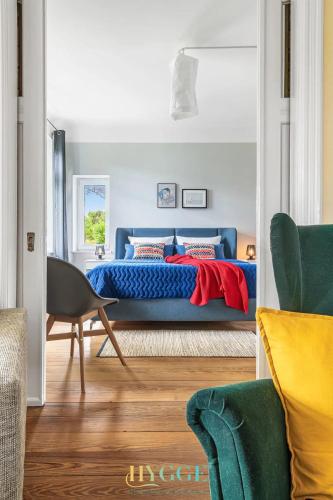 a bedroom with a blue bed and a chair at Villa Hygge Kappeln - Design Ferienwohnungen in Kappeln