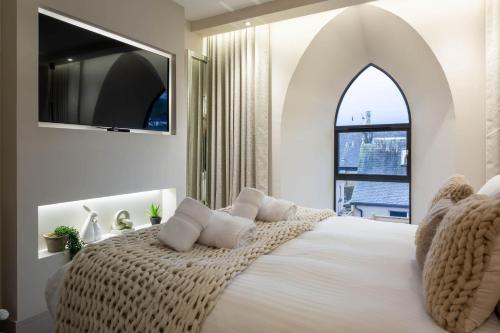 a bedroom with a large white bed with a window at Arran Shores Luxury Shorefront Apartment 4 in Lamlash
