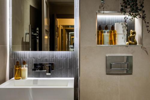 a bathroom with a sink and a mirror at Arran Shores Luxury Shorefront Apartment 4 in Lamlash