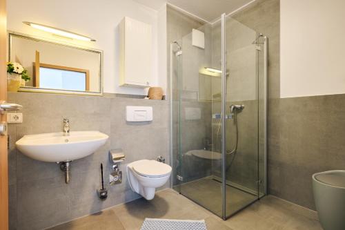 a bathroom with a sink and a toilet and a shower at Ferienwohnung Bootsteg Moba-Travel in Priwall