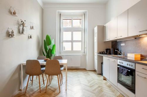 a kitchen with a table and chairs in a room at Boho Living Altstadt Suites - Free Parking by HERO HOMES Graz in Graz