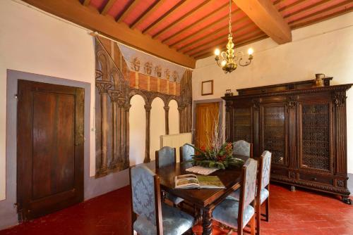 een eetkamer met een tafel en een kroonluchter bij Palazzo Tombesi Trecci in Montepulciano