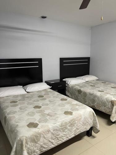 two beds in a room with white walls at Camino de la Plata Hotel in Fresnillo de González Echeverría