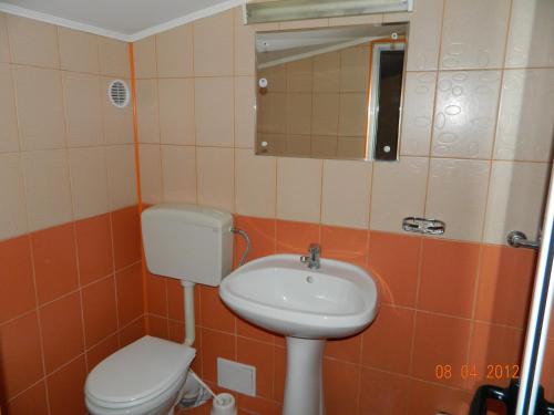a bathroom with a toilet and a sink at Complex Turistic Paralela'45 in Băicoi