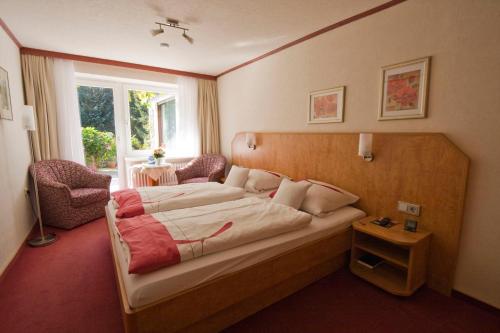 a hotel room with a bed and a window at Mein Vierjahreszeiten Hotel Garni Superior in Sankt Andreasberg
