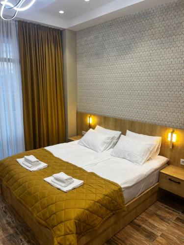 a bedroom with a large bed with towels on it at Seven Rooms Hotel in Tbilisi City