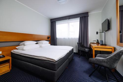 a hotel room with a bed and a desk at Hestia Hotel Ilmarine in Tallinn