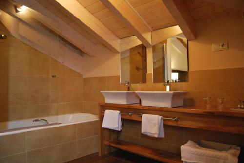 a bathroom with a tub and a sink and a bath tubermott at Hotel Restaurante Puente Romano in Quincoces de Yuso