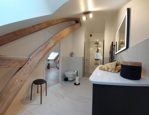 a bathroom with a staircase with a sink and a toilet at La Charmeraie d'Aumâtre in Aumâtre