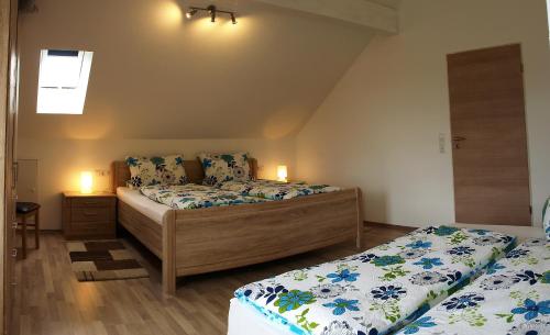 a bedroom with two beds and two lights on the wall at Ferienwohnung Storchenblick in Herbolzheim