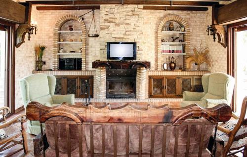 a living room with a fireplace and a tv at Villa Rocio in Setenil