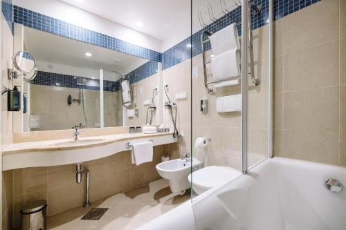 a bathroom with a sink and a toilet and a shower at Hestia Hotel Ilmarine in Tallinn
