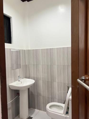 a bathroom with a white toilet and a sink at Bayakyak Soie Residence in General Luna