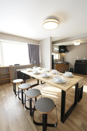 a dining room with a large wooden table and chairs at Yukimi Nakafurano in Nakafurano