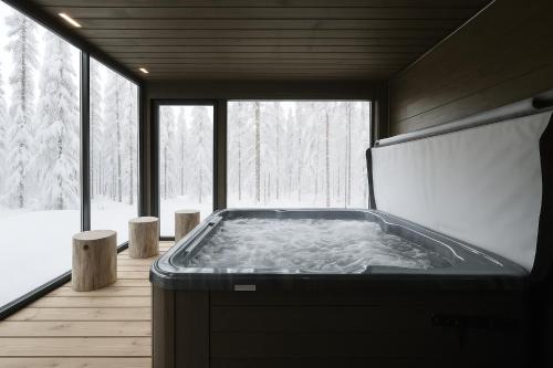 a hot tub in a room with a large window at Villa Taruilevi 3 inc Hot Tub in Levi