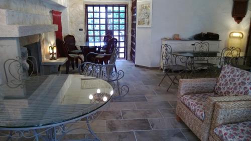 a living room with a glass table and a fireplace at Tamerici House in Montecastrilli