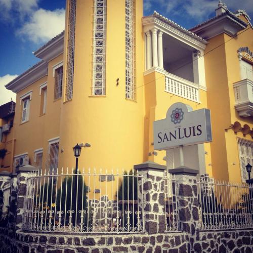 een geel gebouw met een bord ervoor bij San Luis in São Luís