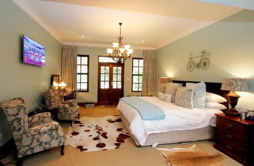 a bedroom with a bed and a tv and a chair at New England Cottage by First Private Stays in Underberg