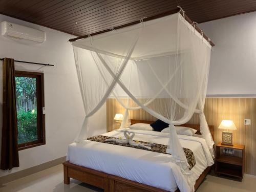 a bedroom with a white bed with a canopy at Abian view house in Sidemen