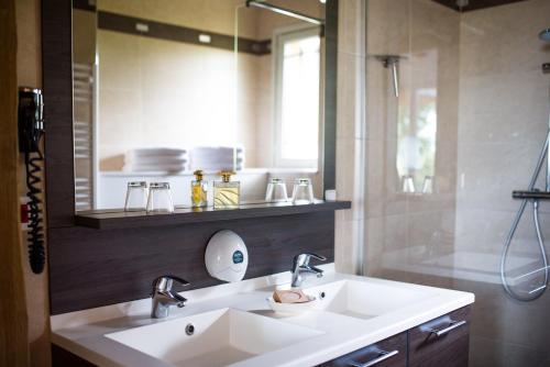 a bathroom with a white sink and a mirror at Holiday home Le clos du phare in Saint-Samson-de-la-Roque