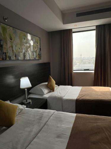 a hotel room with two beds and a window at Hayat Watheer for serviced Apartment in Dammam