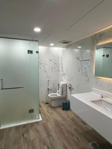 a bathroom with a toilet and a sink at Hayat Watheer for serviced Apartment in Dammam