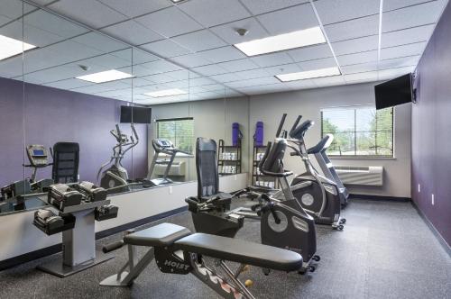 a gym with several treadmills and elliptical machines at Baymont by Wyndham College Station in College Station