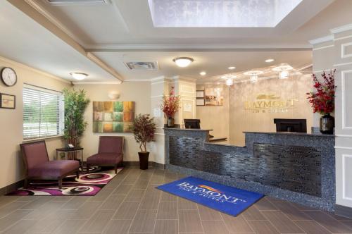 a lobby with a waiting area with chairs and a counter at Baymont by Wyndham College Station in College Station