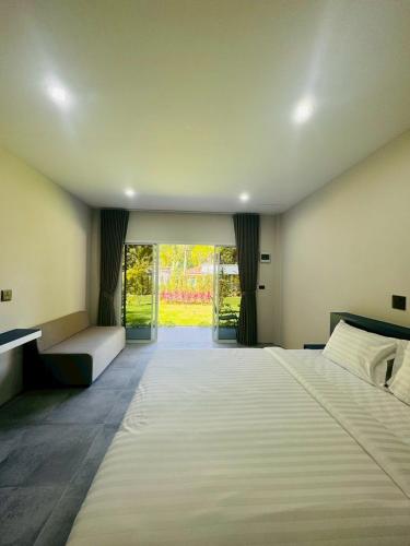 a large bedroom with two beds and a large window at Blue Mountain Kamala Phuket in Kamala Beach
