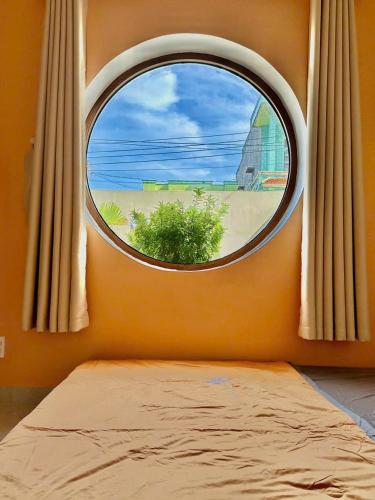 a bedroom with a window with a view of a beach at NEMO house in Cu Lao Thu