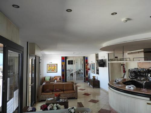 a large living room with a couch and a kitchen at Hotel Rodi Beach FRONTE SPIAGGIA in Rodi Garganico
